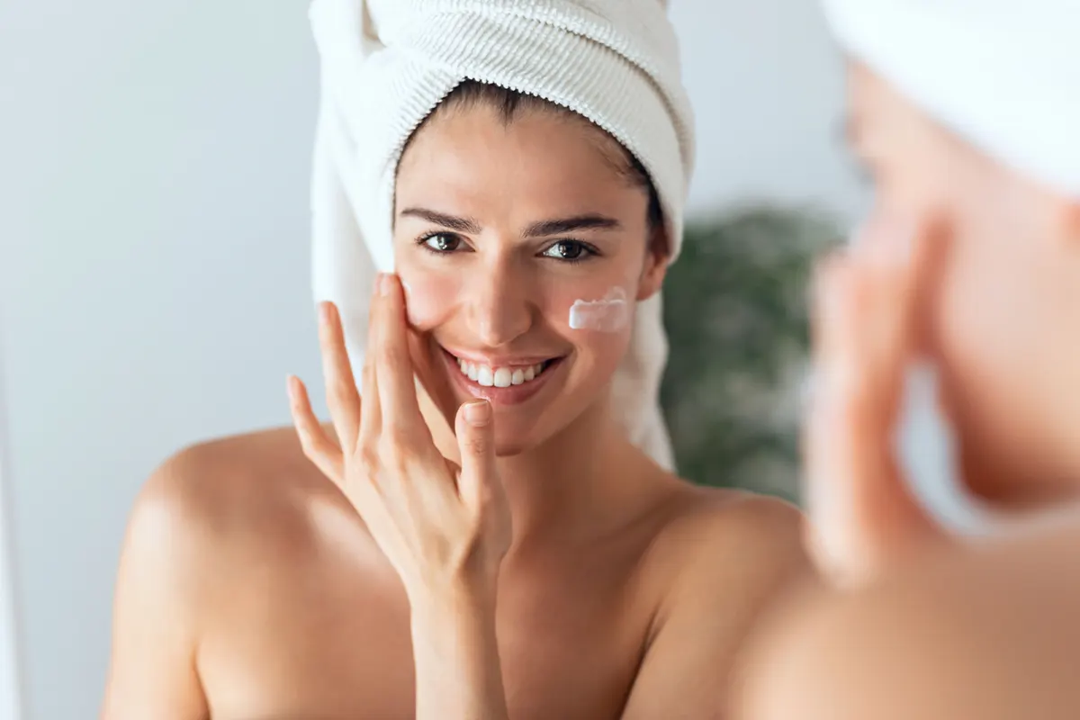 woman-using-cream-in-front-of-the-miror